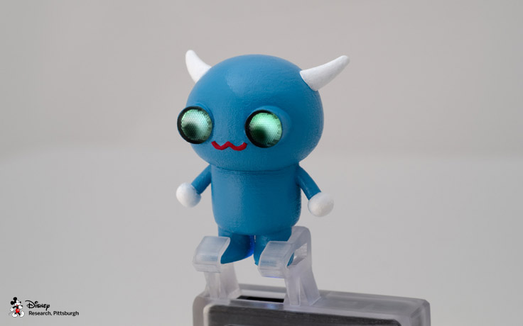 A 3D printed mobile projector accessory with embedded light pipes to map a projected image onto a character's eyes. The character’s eyes respond to user interaction such as sound or physical movement.